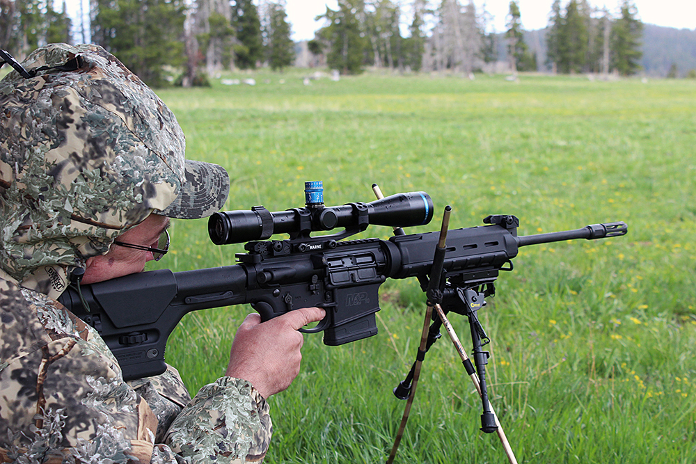 Here, shooter Mike Dickerson props himself up against a tree and takes the 600 yard shot, tensioning his bipod on the shooting sticks for a rock solid platform.