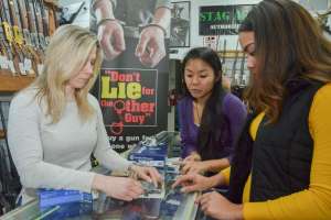 Customers 1 women in gun shop buying at counter NSSF photo